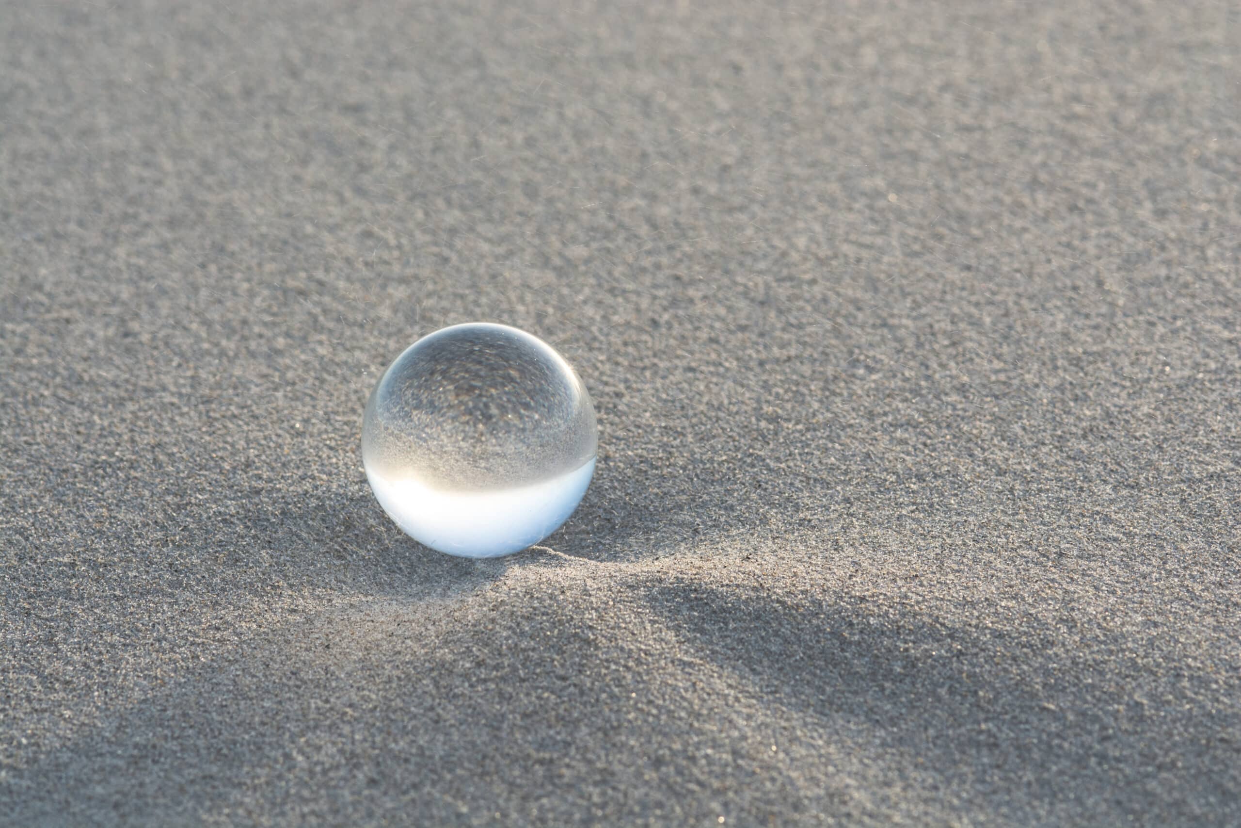 Glazen bal in het zand